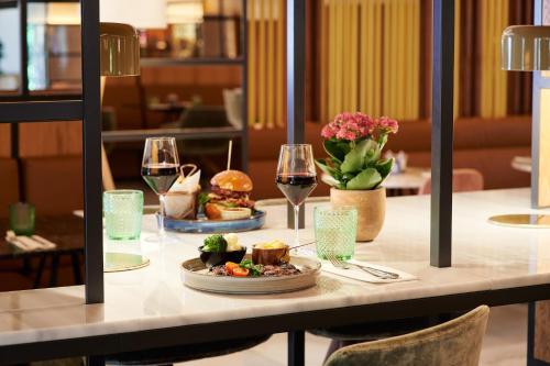 a table with two plates of food and glasses of wine at The Level at Melia White House in London