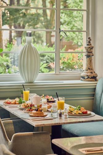 a table with plates of food and drinks on it at The Level at Melia White House in London