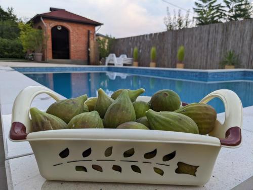 a basket of watermelons sitting next to a pool at Wisteria Lodge in Derventa