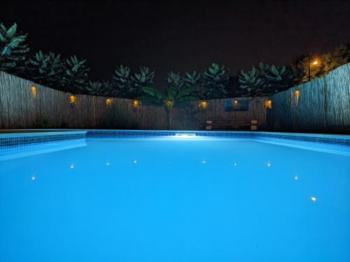 een zwembad 's nachts met een hek bij Wisteria Lodge in Derventa