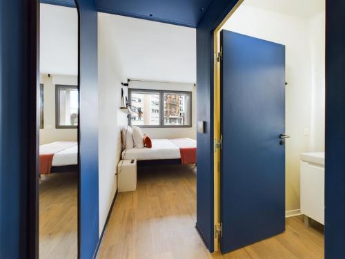 a door leading into a room with two beds at Hife Gentilly Paris Sud Porte d'Italie in Gentilly