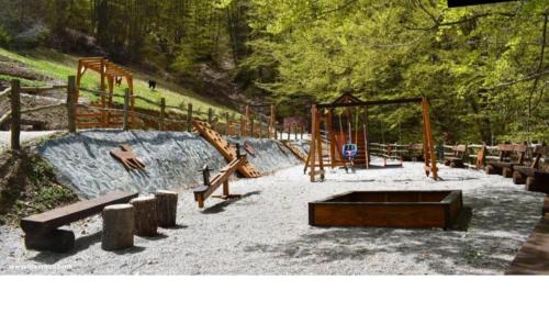um parque com um parque infantil com escorregas e baloiços em Mavrovo Centar Ski Staza em Mavrovo