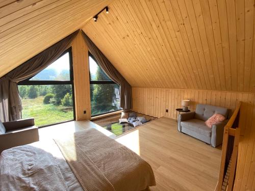 a room with a bed and a large window at Love Wysove in Wysowa-Zdrój