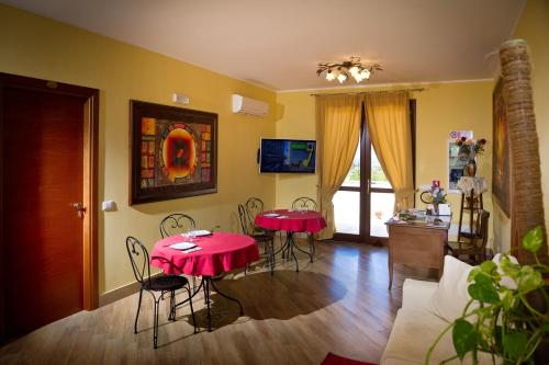 Una sala de estar con dos mesas y sillas rojas. en Al Cantuccio, en Castelluzzo