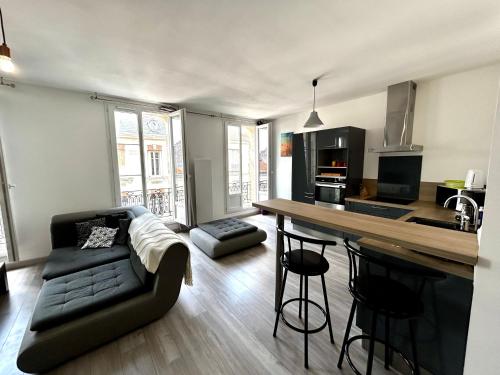 une cuisine et un salon avec un canapé et une table dans l'établissement Le République - Logements avec jardin situés en plein cœur de ville et proche des thermes, à Rochefort