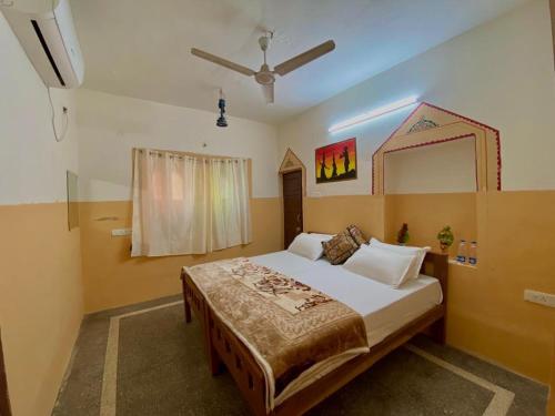 1 dormitorio con 1 cama grande y ventilador de techo en Hotel Sandstone Villa,, en Jaisalmer