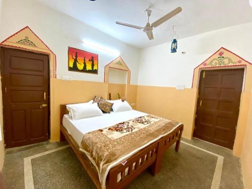 1 dormitorio con 1 cama y 2 puertas en Hotel Sandstone Villa,, en Jaisalmer