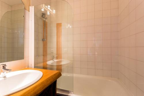 a bathroom with a sink and a shower and a tub at Zenith Appartements VTI in Val Thorens