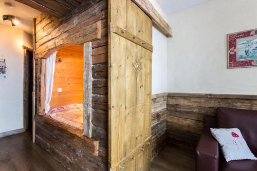 a wooden cabin with a bed in a room at Zenith Appartements VTI in Val Thorens