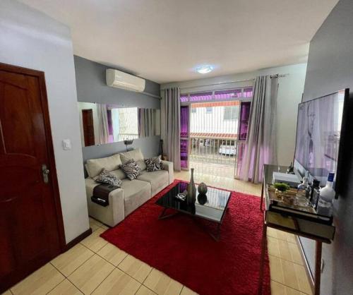 uma sala de estar com um sofá branco e um tapete vermelho em Apartamento completo 2 quartos em Macapá