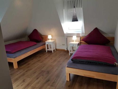 a bedroom with two beds and two lights on two tables at Ferienhaus Gesine 25193 in Bunde