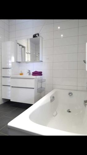 a white kitchen with a tub and a sink at Ferienhaus Gesine 25193 in Bunde