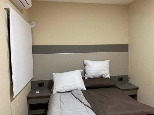 una camera con un letto con due cuscini sopra di Departamento Barcelona a Formosa