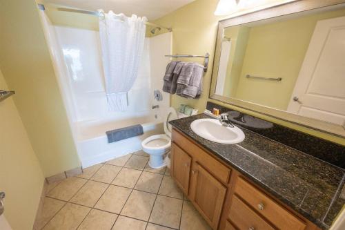 a bathroom with a sink and a toilet and a mirror at Low Floor,Direct Oceanfront,Heated Pool,Boardwalk! in Myrtle Beach