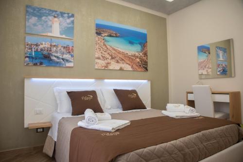 Un dormitorio con una cama grande con toallas. en Pelagie Home, en Porto Empedocle
