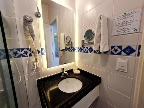 a bathroom with a sink and a mirror at Belle Arti Pousada in Florianópolis