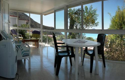 a dining room with a table and chairs and windows at Camping Naturista El Portús - Nudist FKK in Cartagena