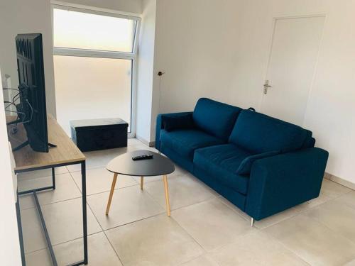 un salon avec un canapé bleu et une table dans l'établissement Le Relais des Brias, à Saint-Martin-Lacaussade