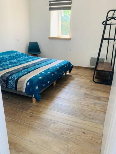 une chambre avec un lit et un parquet dans l'établissement Le Relais des Brias, à Saint-Martin-Lacaussade