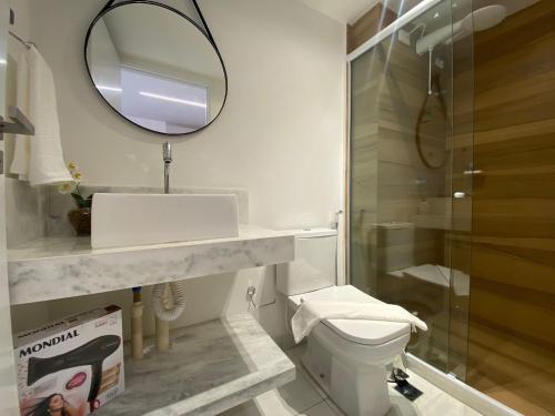 Un baño con lavabo, inodoro y espejo. en Bela Hospedagem - #Unity Flats Cabo Branco, en João Pessoa