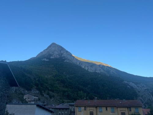 Une montagne au loin avec des maisons devant elle dans l'établissement Chambre d'hôte cocooning, à Tende
