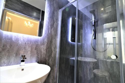 a bathroom with a sink and a glass shower at Signature - Linden House Flat 4 in Airdrie