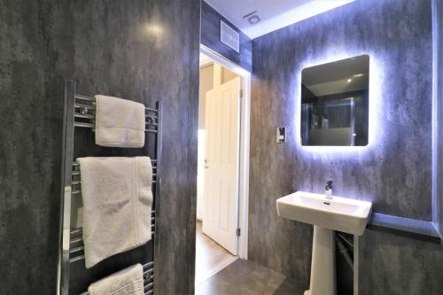 a bathroom with a sink and a mirror at Signature - Linden House Flat 3 in Airdrie