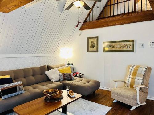 een woonkamer met een bank, een tafel en een stoel bij New-ski-spa-outdoor-fireplace-Mont Orford in Orford