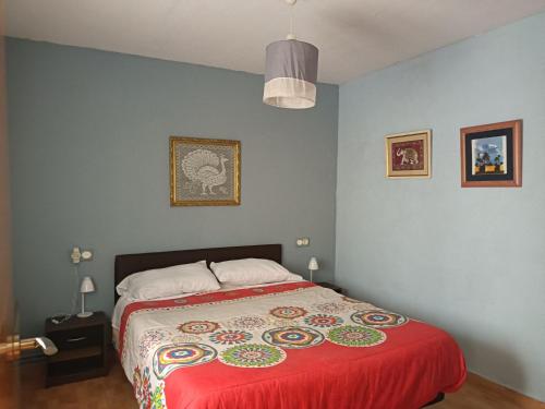 a bedroom with a bed with a red blanket at CASA LOS BLOQUES in Zamora