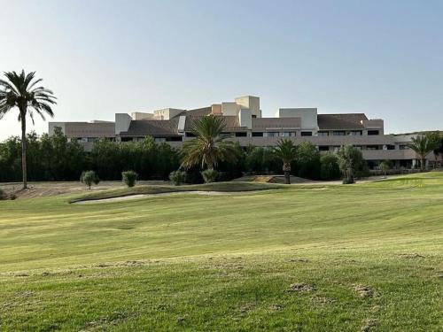 um campo de golfe com um edifício ao fundo em Zen garden apartment. em Vera