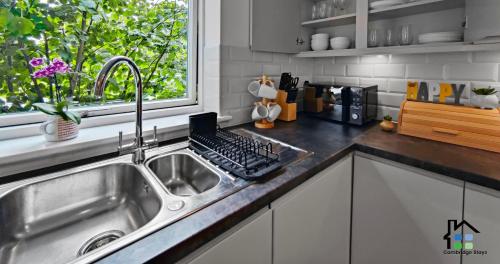 a kitchen with a sink and a laptop on the counter at Riverside - 2BR & 1BR - Flat Walk to Centre with open Parking in Cambridge