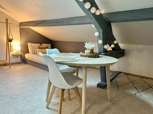 een tafel en stoelen in een kamer met een bed bij Studio Calme et Cosy -Gare- in Bourg-en-Bresse