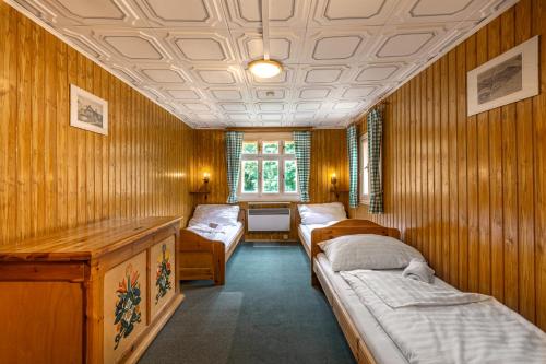 哲汀泊德勒瓦的住宿－Chata Zvoneček，带三张床、桌子和窗户的房间
