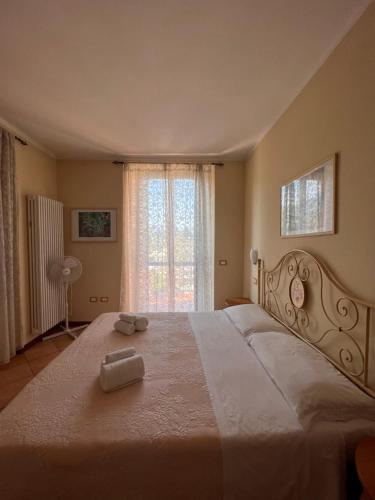 um quarto com uma grande cama branca e uma janela em B&B Terra & Sole em Novafeltria