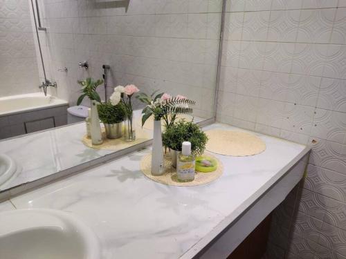 شقة MAF العليا كومباوند155 في الرياض: منضدة الحمام مع حوض والزهور عليه