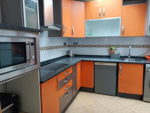 cocina con armarios de color naranja y fregadero en CASA LOS BLOQUES en Zamora