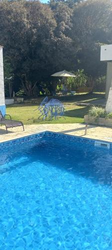 une grande piscine bleue dans une cour dans l'établissement Chalézinho Santorini, à Guararema