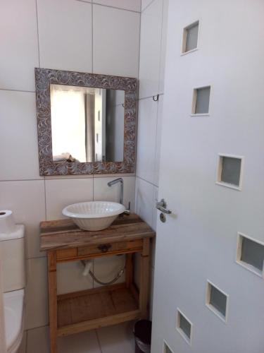 a bathroom with a sink and a mirror at Chalézinho Santorini in Guararema