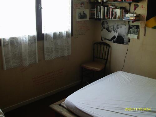 - une chambre avec un lit, une chaise et une fenêtre dans l'établissement torres, à Villecresnes