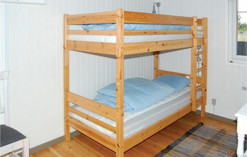 a bunk bed with blue pillows on the bottom bunk at 3 Bedroom Beautiful Home In Rm in Bolilmark