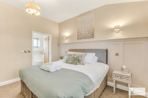a bedroom with a large white bed with towels on it at Silver Stag Properties, 1 BR Slate Lodge 