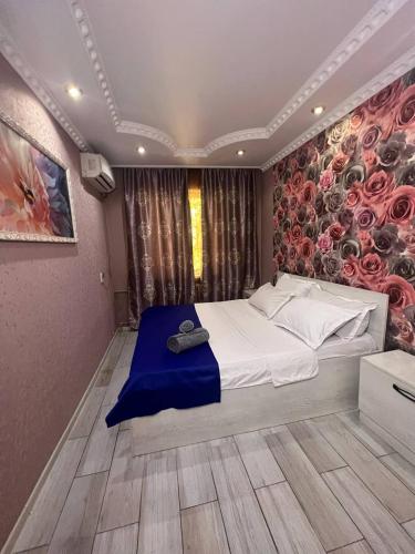 ein Schlafzimmer mit einem großen Bett mit Blumenwand in der Unterkunft 15 Apartments in Schymkent