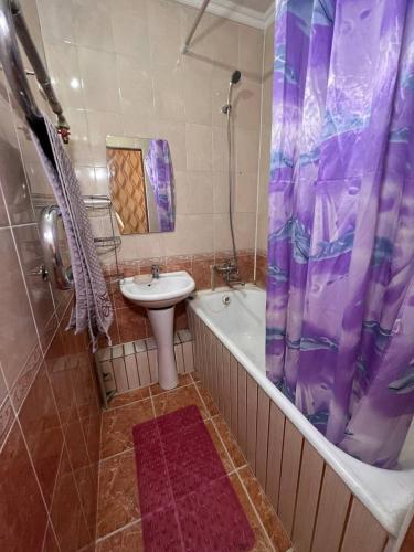 y baño con bañera, lavamanos y ducha. en Апартаменты на Mege, en Shymkent
