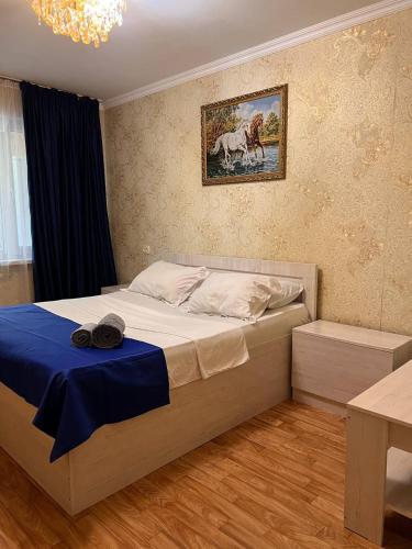 una camera da letto con un grande letto con una coperta blu di Апартаменты на Mege a Shymkent