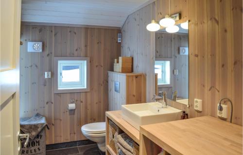 a bathroom with wooden walls and a sink and a toilet at Awesome Home In Etnedal With House A Mountain View in Etnedal