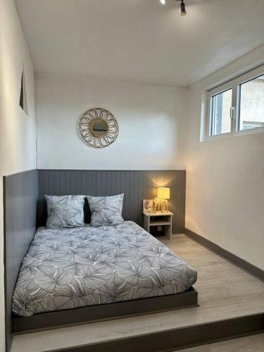 une chambre avec un lit et un miroir au mur dans l'établissement Joli studio à 3 min de la Gare, à Bourg-en-Bresse