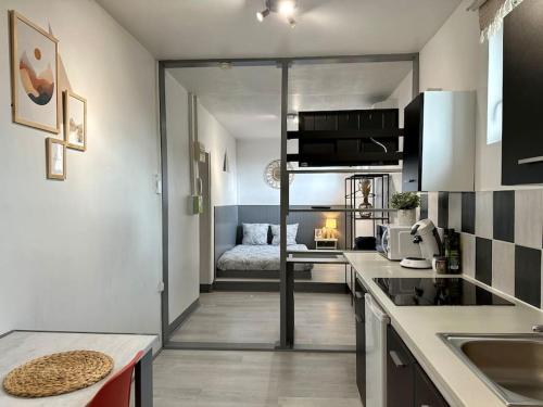 a kitchen with a room with a bed in it at Joli studio à 3 min de la Gare in Bourg-en-Bresse