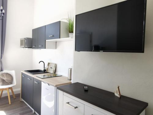 アールベックにあるFerienwohnung MeerZeit Villa Adlerのキッチン(壁に大画面薄型テレビ付)