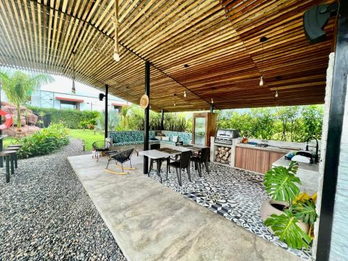 an outdoor patio with a table and a kitchen at QUINTA LA COLONIA in Restrepo