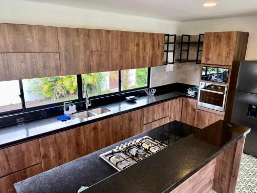 a kitchen with wooden cabinets and a black counter top at QUINTA LA COLONIA in Restrepo